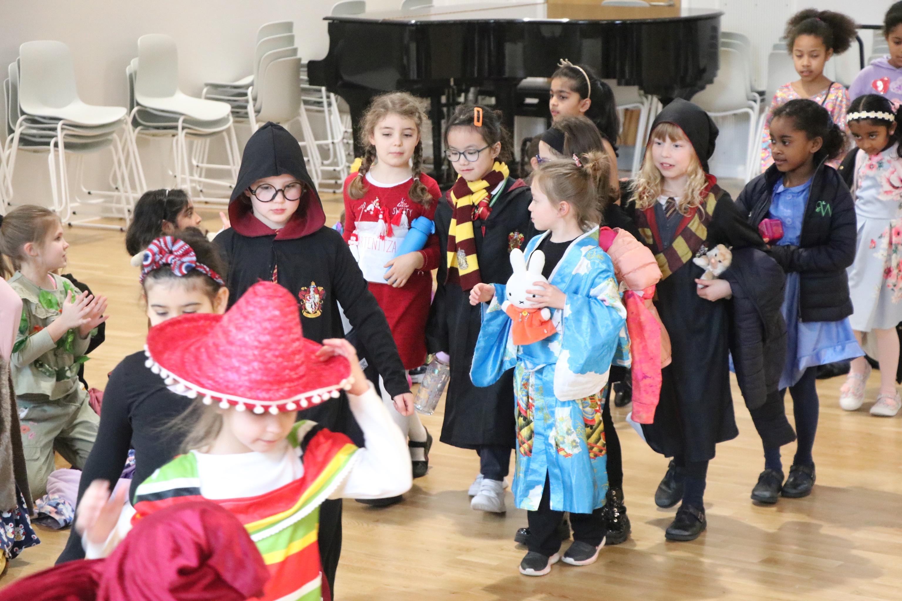 A photograph of lower junior school girls walking. They are all wearing different costumes for World Book Day